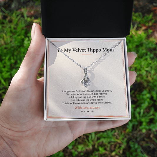 Velvet Hippo Mom Alluring Beauty necklace held in hand showing pendant and message card